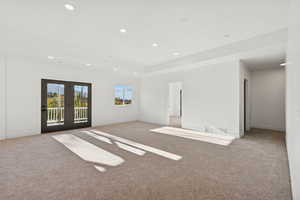 Empty room featuring carpet, recessed lighting, and a raised ceiling
