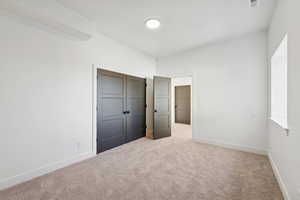 Unfurnished bedroom with carpet floors and a closet