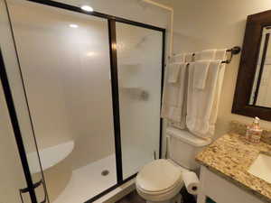 Full bath with vanity and a shower stall
