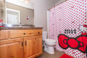 Bathroom featuring curtained shower, vanity, and tile patterned flooring