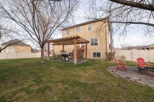 Rear view of house with a patio area, a pergola, a fenced backyard, stucco siding, and an outdoor fire pit