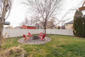 Fenced backyard with a patio area and an outdoor fire pit