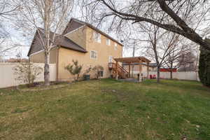 Rear view of property with a fenced backyard, stucco siding, roof with shingles, a deck, and stairs