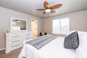 Bedroom featuring light colored carpet and a ceiling fan
