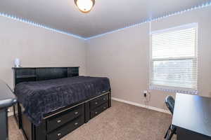 Bedroom featuring carpet floors and baseboards