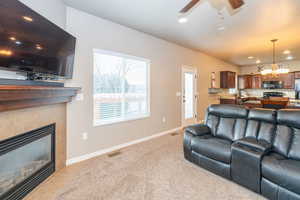 Living room featuring recessed lighting, ceiling fan, light carpet, and a tiled fireplace