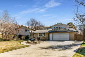 View of front of property featuring concrete driveway, brick siding, a metal roof, and an attached garage