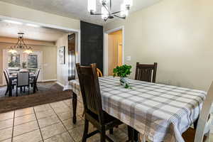 Kitchen eating with a chandelier, tile patterned floors, looking into dining room