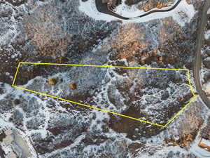 Snowy aerial view featuring property parcel outlined