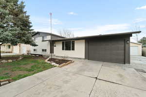 Tri-level home with concrete driveway and a garage