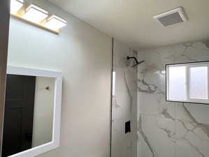 Bathroom with a marble finish shower