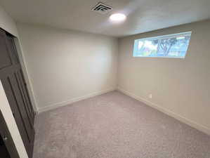 Unfurnished bedroom with light colored carpet and a textured ceiling