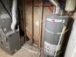Utility room featuring strapped water heater and heating unit