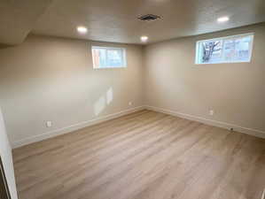 Below grade area featuring light wood-style flooring and recessed lighting