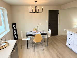 Dining space featuring light wood finished floors and a chandelier