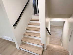 Stairs featuring wood finished floors and baseboards