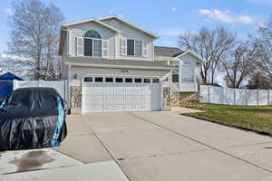 View of front facade featuring a garage, concrete driveway, and a shingled roof