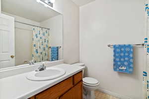 Full bath with a shower with curtain, vanity, and light flooring