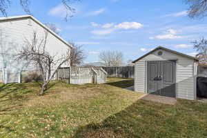 Fenced backyard with a shed and a deck