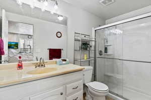 Full bathroom featuring a stall shower, vanity, and a textured ceiling
