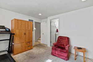 Workout area with light carpet, a textured ceiling, and recessed lighting