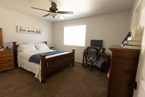 Bedroom featuring dark colored carpet and ceiling fan