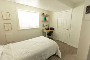 Bedroom with carpet floors and a textured ceiling