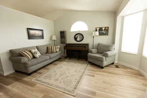 Living room with lofted ceiling and light wood-style floors