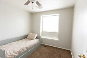 Carpeted bedroom with baseboards and ceiling fan