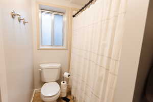 Bathroom with a shower with curtain and toilet