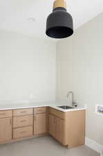 Laundry room featuring light tile patterned floors, washer hookup, and cabinet space
