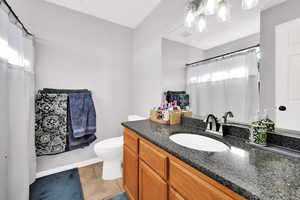Bathroom featuring vanity, curtained shower, and light tile patterned flooring