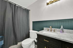 Full bathroom with vanity and wainscoting