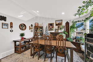 Dining room featuring lofted ceiling and light wood-type flooring