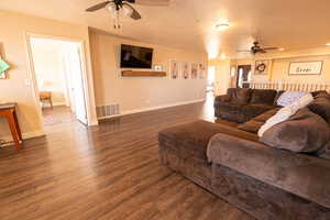Living room with a ceiling fan, wood finished floors, a textured ceiling, and recessed lighting