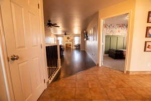 Corridor with light tile patterned flooring and baseboards