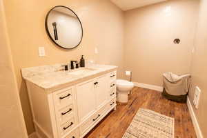 Half bathroom featuring vanity and light wood finished floors