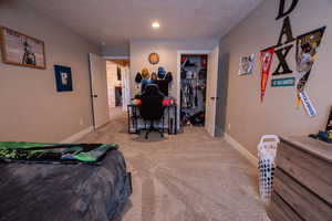 Carpeted bedroom featuring a spacious closet and baseboards