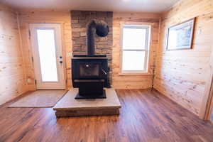 Detailed view of a wood stove, wood finished floors, and wood walls