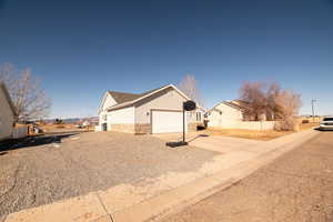 View of home's exterior featuring concrete driveway, a residential view, stone siding, and an attached garage
