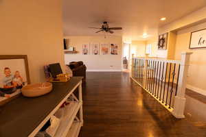 Corridor with dark wood-type flooring and recessed lighting