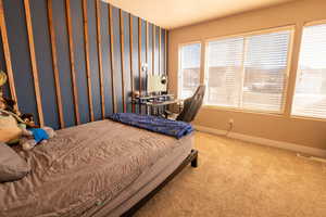 Bedroom with wallpapered walls and carpet floors