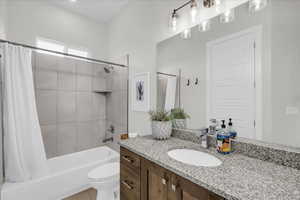 Full bath with shower / bath combo with shower curtain and vanity