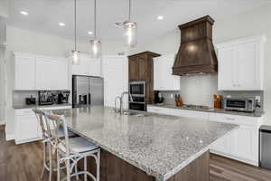 Kitchen with backsplash, light stone countertops, dark wood finished floors, and recessed lighting