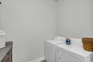 Laundry area featuring baseboards and washing machine and clothes dryer