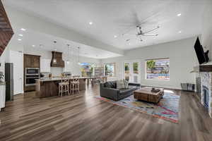 Living room featuring dark wood-style floors, a fireplace, and recessed lighting