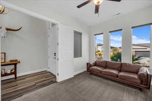 Living area featuring baseboards and a ceiling fan