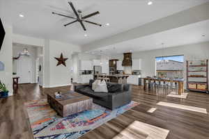 Living room with a chandelier, dark wood-type flooring, a ceiling fan, and recessed lighting