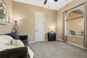 Living area featuring carpet, ceiling fan, and lofted ceiling