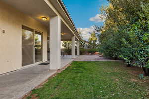 View of green lawn with a patio area